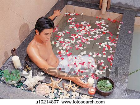 Stock Photo - Male in a bathtub full of rose petals. Fotosearch