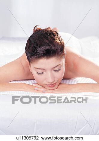 Stock Image - Lying On Front, Beauty, Content, One Young Woman Only, Care, Beauty Spa, Bodycare & Make Up. Fotosearch