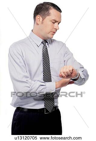 Stock Photography - looking at time, standing, watch, professional, culture. Fotosearch