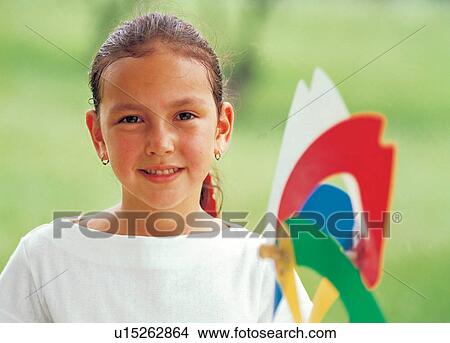 Picture - girl, 6-7 years, grass, looking at camera, holding. Fotosearch