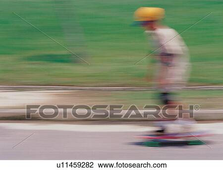 Stock Image - green, blurred, child, portrait, board skating, childhood. Fotosearch