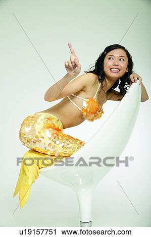 Stock Image - Gesturing, Bizarre, Long Hair, Smiling, Chair, One Person. Fotosearch