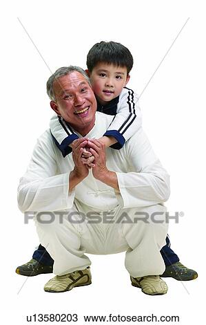 Stock Image - Mature Adult, Crouching, Boys, Black Hair, 6-7 Years, Smiling, Bending. Fotosearch