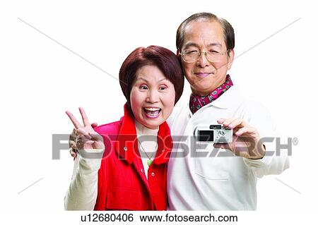 Stock Photograph - Standing, Mature Couple, Communication, Family, Short Hair, Digital Camera. Fotosearch