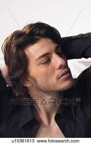Stock Image - Brown Hair, Indoor, One Young Man Only, Hands Behind Head, Human Face. Fotosearch