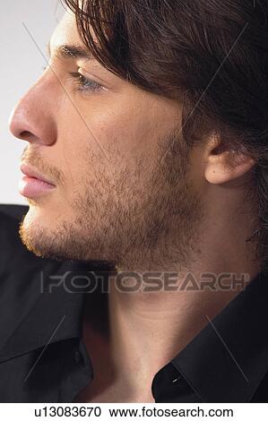 Stock Image - Button Down Shirt, One Person, Indoor, Young Adult, Contemplation, Individuality. Fotosearch