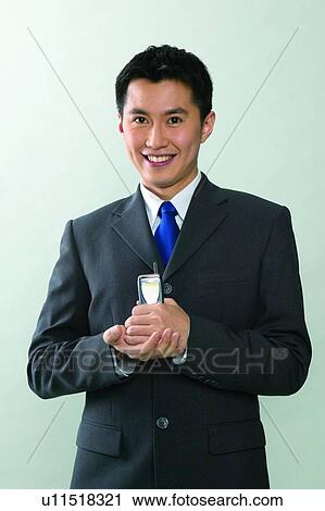 Stock Image - Black Hair, Communication, Mobility, Holding, Formal Clothing, Standing. Fotosearch