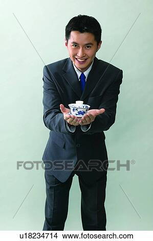 Picture - Close-Up, Indoor, Black Hair, Smiling, Business Suit, Holding. Fotosearch