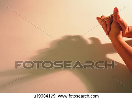 Stock Photo - shadow, thumb, hands, clasped. Fotosearch