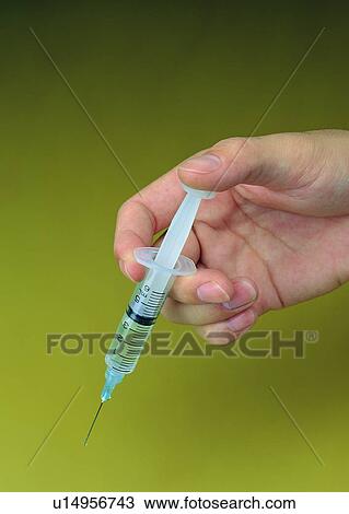 Stock Image - syringe, needle, hand, finger. Fotosearch