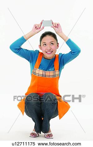 Casual Clothing, Arms Raised, Brown Hair, Body Language, Asian Ethnicity, Apron View Large Photo Image Stock Photography - Casual Clothing, Arms Raised, Brown Hair, Body Language, Asian Ethnicity, Apron. Fotosearch