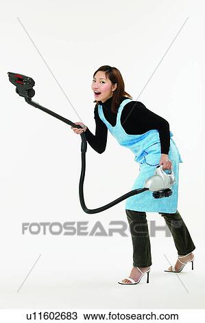 Stock Image - Casual Clothing, Asian Ethnicity, Brown Hair, Body Language, Bending, Apron. Fotosearch