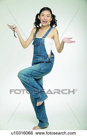 Stock Photo - Laughing, Indoor, Hand On Hip, Standing On One Leg, Young Adult. Fotosearch