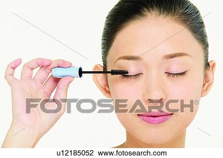 Stock Image - Asian Ethnicity, Close-Up, Black Hair, Applying. Fotosearch