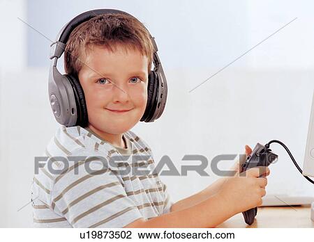 Stock Image - innocence, t-shirt, computer, lifestyle, portrait, electronic device. Fotosearch