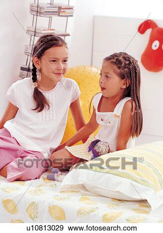Stock Photo - lifestyle, childhood, brown hair, medium length hair, fun, pillow. Fotosearch