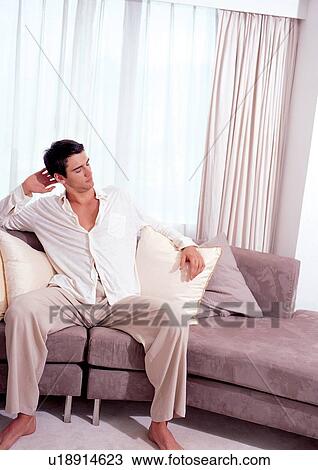 Stock Image - day, model, looking side ways, one person, couch, indoor. Fotosearch