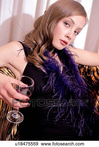Stock Photo - fashion model, cosmetic, lifestyle, alcohol, couch, home interior. Fotosearch