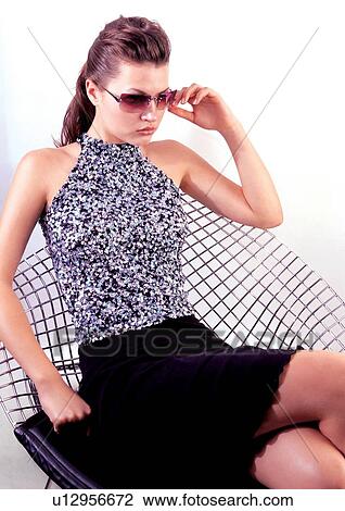 Stock Image - fashion model, furniture, posing, brown hair, indoor. Fotosearch