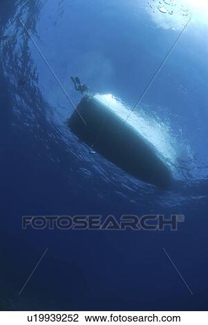 Stock Image - Dive boat silhouette against surface, Cayman Islands, Caribbean. Fotosearch