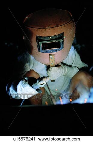Stock Image - Indoor, Protection, Engineering, Welding, Protective Suit, Unrecognizable Person. Fotosearch