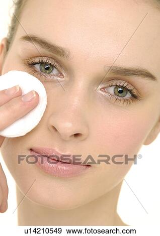 Stock Photo - Close-up of a young woman applying face powder. Fotosearch