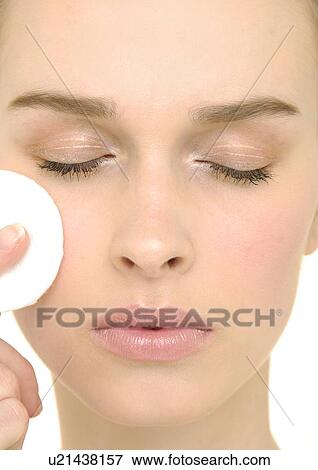 Close-up of a young woman applying powder compact View Large Photo Image Stock Photo - Close-up of a young woman applying powder compact. Fotosearch