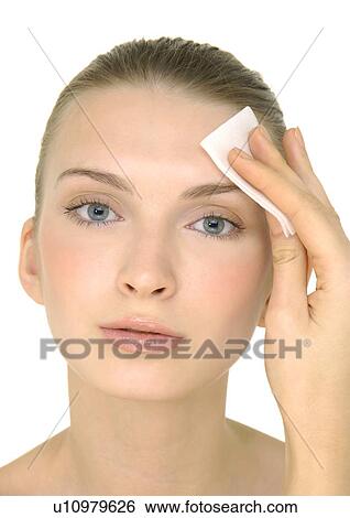 Close-up of a young woman cleaning her face with a facial brush View Large Photo Image Stock Photograph - Close-up of a young woman cleaning her face with a facial brush. Fotosearch