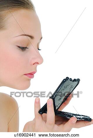 Close-up of a young woman looking at a hand mirror View Large Photo Image Stock Image - Close-up of a young woman looking at a hand mirror. Fotosearch