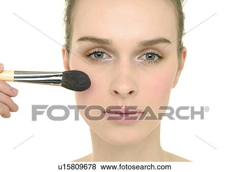 Portrait of a young woman applying blush View Large Photo Image Stock Photo - Portrait of a young woman applying blush. Fotosearch