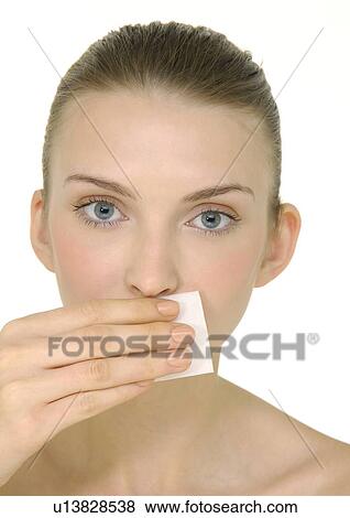 Stock Photo - Portrait of a young woman applying face powder. Fotosearch