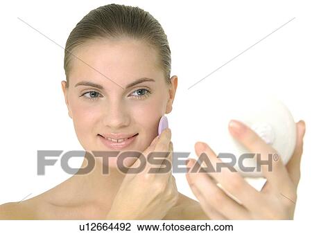 Young woman applying face powder and smiling View Large Photo Image Stock Image - Young woman applying face powder and smiling. Fotosearch