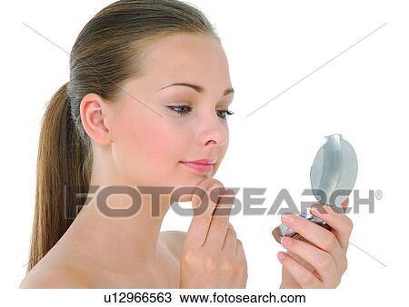 Young woman looking at a hand mirror View Large Photo Image Stock Image - Young woman looking at a hand mirror. Fotosearch