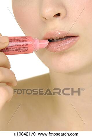 Close-up of a young woman applying lip balm View Large Photo Image Stock Image - Close-up of a young woman applying lip balm. Fotosearch