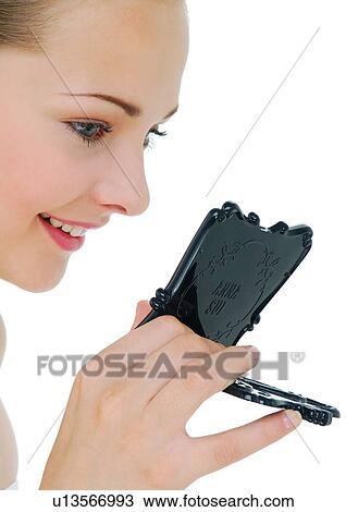 Close-up of a young woman looking at a hand mirror and smiling View Large Photo Image Stock Image - Close-up of a young woman looking at a hand mirror and smiling. Fotosearch