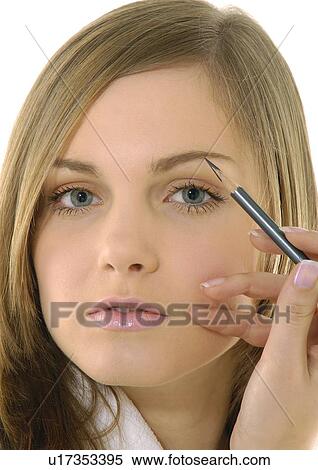 Portrait of a young woman applying an eyebrow pencil View Large Photo Image Stock Photography - Portrait of a young woman applying an eyebrow pencil. Fotosearch