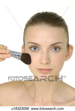 Portrait of a young woman applying blush View Large Photo Image Stock Photograph - Portrait of a young woman applying blush. Fotosearch