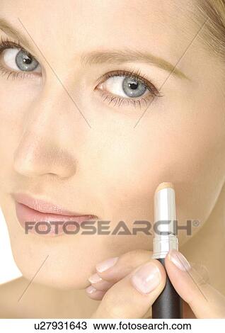 Portrait of a young woman applying concealing stick on her cheek View Large Photo Image Stock Image - Portrait of a young woman applying concealing stick on her cheek. Fotosearch