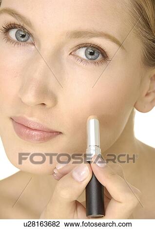 Portrait of a young woman applying concealing stick on her cheek View Large Photo Image Stock Image - Portrait of a young woman applying concealing stick on her cheek. Fotosearch