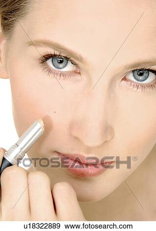 Portrait of a young woman applying concealing stick on her cheek View Large Photo Image Stock Photo - Portrait of a young woman applying concealing stick on her cheek. Fotosearch