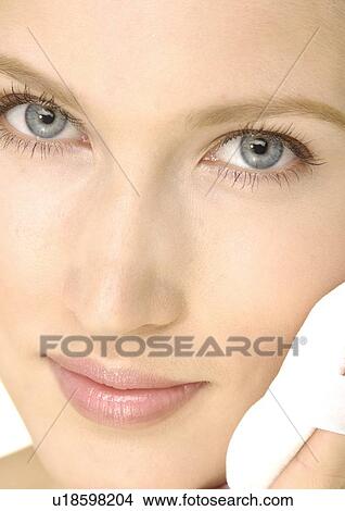 Portrait of a young woman using powder puff View Large Photo Image Picture - Portrait of a young woman using powder puff. Fotosearch