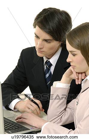 Stock Photography - Businessman and a businesswoman working on a laptop. Fotosearch