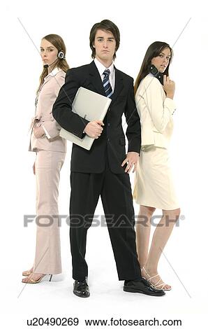 Stock Photo - Portrait of a businessman holding a laptop with two businesswomen standing behind him. Fotosearch