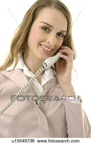 Stock Photograph - Portrait of a businesswoman talking on the telephone and smiling. Fotosearch