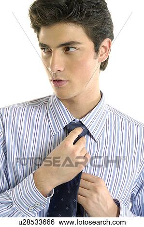 Stock Photograph - Businessman adjusting his tie and looking away. Fotosearch