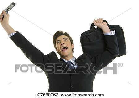 Stock Image - Businessman shouting and holding a mobile phone. Fotosearch