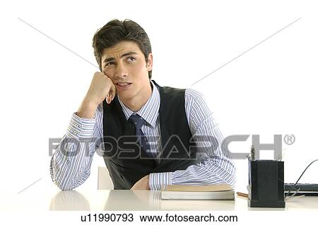 Stock Image - Businessman sitting at a desk and thinking. Fotosearch