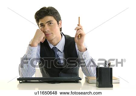 Stock Photo - Businessman sitting at a desk in an office. Fotosearch