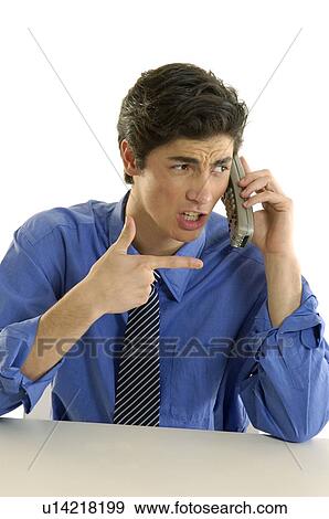 Businessman talking on a cordless phone and looking frustrated View Large Photo Image Stock Photo - Businessman talking on a cordless phone and looking frustrated. Fotosearch