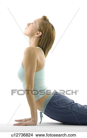Picture - Young woman lying in cobra pose. Fotosearch